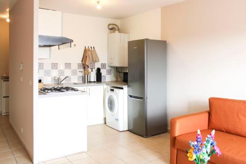 Il comprend une petite cuisine équipée d'un réfrigérateur et d'un canapé. dans l'établissement Apartment with balcony near the city center, à Saint-Denis