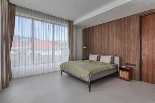 a bedroom with a bed and a large window at Stark villas - modern villa with roof top in Uluwatu