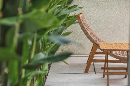a wooden chair next to a table and a plant at Stark villas - modern villa with roof top in Uluwatu