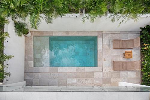 a swimming pool in a building with palm trees at Stark villas - modern villa with roof top in Uluwatu