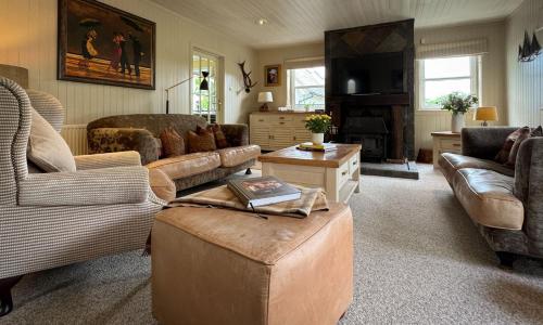 a large living room with couches and a table at Stunning country home with Hot Tub and Sauna in Strachur