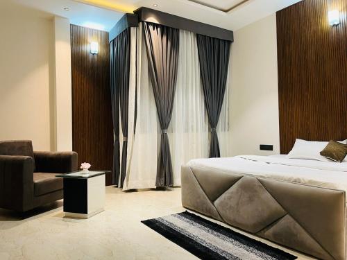 a bedroom with a bed and a couch and a chair at The Divine Villa ! in Indore