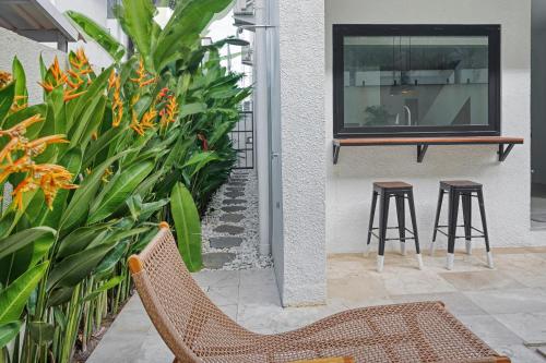 a patio with two chairs and a table and some plants at Stark villas - modern villa with roof top in Uluwatu