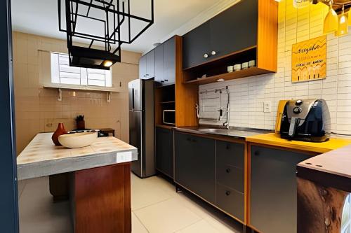 a kitchen with black cabinets and a counter top at Apto 2 quartos - Encanto de Belém in Curro Velho