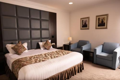 Una habitación de hotel con una cama y dos sillas. en فندق ابرال الفندقية, en Medina