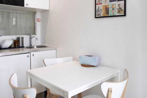 une table blanche et des chaises dans une cuisine dans l'établissement Charming and bright in the heart of Paris, à Paris