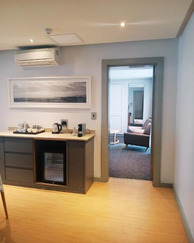 a living room with a kitchen and a living room with a couch at Krystal Beach Hotel in Gordonʼs Bay