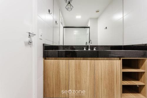 a bathroom with a sink and a mirror at HMO - Estúdios completos em prédio c/ piscina in Sao Paulo