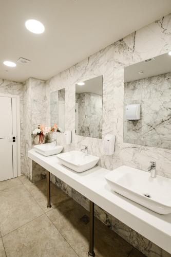 a bathroom with two sinks and two mirrors at Hotel Laguna Park Sunrise in Sunny Beach