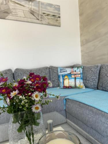 a living room with a couch and a vase of flowers at Fisherman's House Gušti in Kamenari