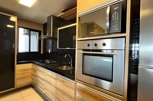 a kitchen with a stainless steel oven and microwave at Apto 2 suítes - Umarizal in Curro Velho