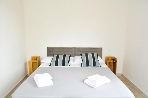 una camera con un letto bianco con due cuscini di Ostia Holiday Kama 2 a Lido di Ostia