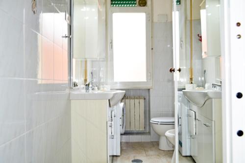 bagno bianco con 2 lavandini e servizi igienici di Ostia Holiday Kama 2 a Lido di Ostia
