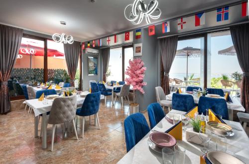 a restaurant with tables and chairs and windows at Sea View Hills in Sveti Vlas