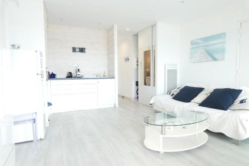 un salon blanc avec un canapé et une table dans l'établissement Ocean vert - front de mer - balcon, à La Baule