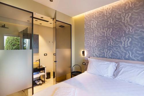 a bedroom with a bed and a glass wall at Uefio - Boutique Stay in Bacoli