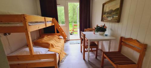 a room with a bunk bed and a table with a desk at Romsdalseggen Camping in Isfjorden