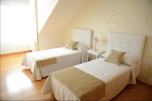 Una habitación de hotel con dos camas y una ventana. en P17 Nuevo Atico Isla de la Toja, en O Grove