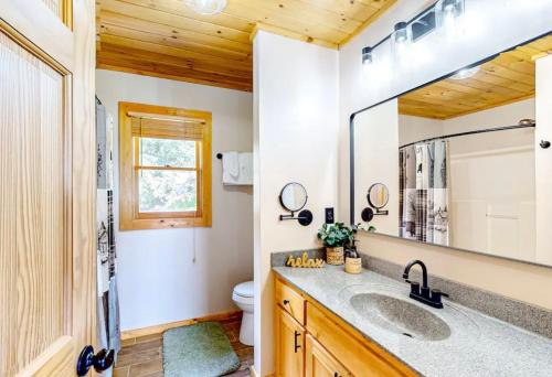 a bathroom with a sink and a mirror at Grandpa John Cabin - Hot Tub, Game Room in Sugar Grove