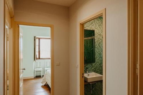 a bathroom with a sink and a mirror at Casa do Sorrio - Slow Down, Live Now in Viana do Castelo
