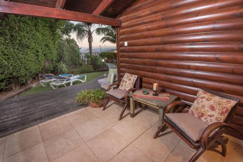 a patio with chairs and a table with a candle at כחול ירוק בכפר - בקתות מהממות עם ג'קוזי ובריכה מחוממת in Had Nes