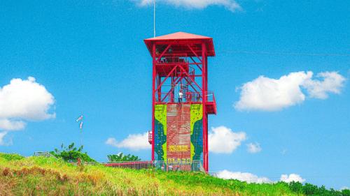a red tower on top of a hill with a blue sky at Holiday Inn & Suites Batangas LimaPark by IHG in Batangas City