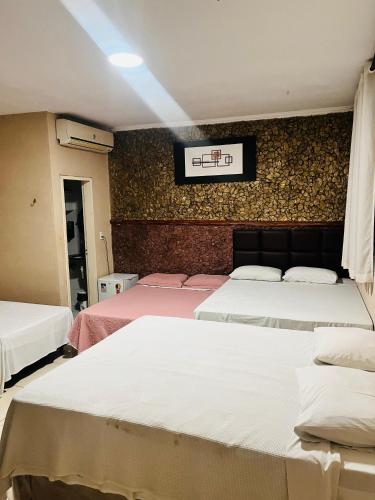 a room with three beds and a scoreboard on the wall at Hotel Nacional in Sobral