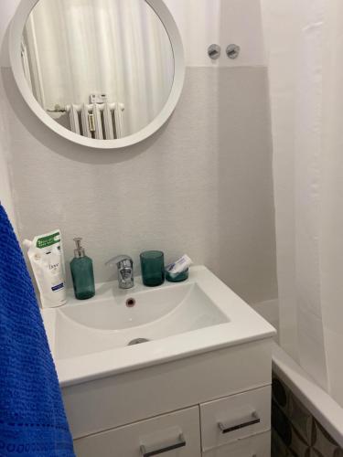 a bathroom with a white sink and a mirror at Apartament Piastowska in Gliwice