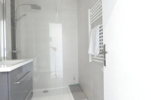 une salle de bain blanche avec une douche et un lavabo dans l'établissement OCEAN BLEU - front de mer et balcon, à La Baule