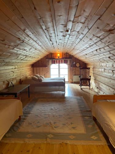 1 dormitorio en una cabaña de madera con cama y ventana en Tarina-Aho Resort, en Vuonislahti