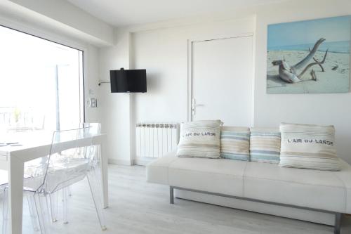 un salon blanc avec un canapé blanc et une table dans l'établissement OCEAN BLEU - front de mer et balcon, à La Baule
