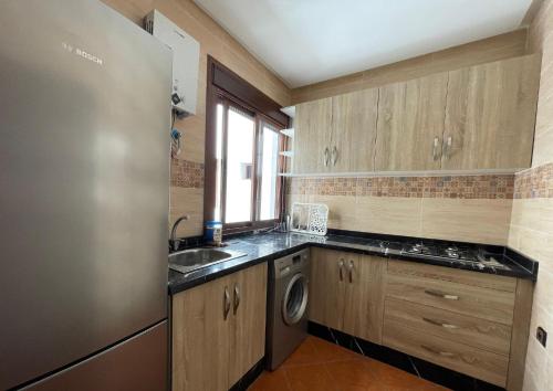 a small kitchen with a sink and a dishwasher at CALA DEL SOL Résidences CHMAALA in Ifargane