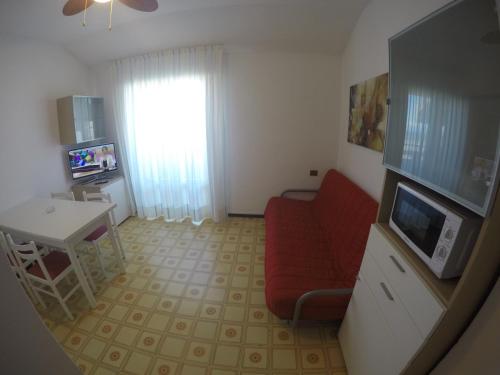 a living room with a red couch and a television at Residence Zenith in Caorle