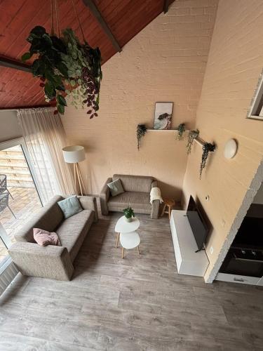 a living room with a couch and a tv at Brand new beachhouse Sand & Meer - Near beach in Bruinisse