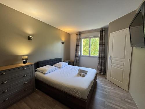 a bedroom with a bed with a dresser and a window at LOrée du Bois - 14 personnes - Rêve au Mans in Montfort-le-Gesnois