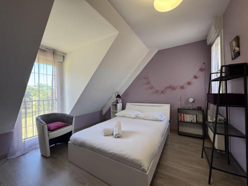 a bedroom with a white bed and a chair at LOrée du Bois - 14 personnes - Rêve au Mans in Montfort-le-Gesnois