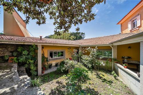 a yellow house with a garden in front of it at Refúgio entre o Pomar e o Rio Douro in Raiva