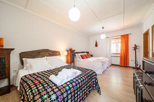 a bedroom with two beds and a cross on the wall at Refúgio entre o Pomar e o Rio Douro in Raiva
