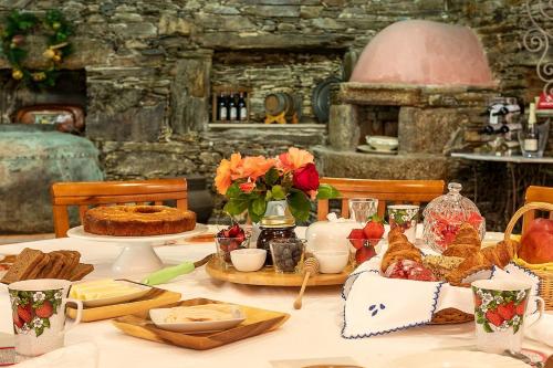 a table with food and flowers on top of it at Refúgio entre o Pomar e o Rio Douro in Raiva