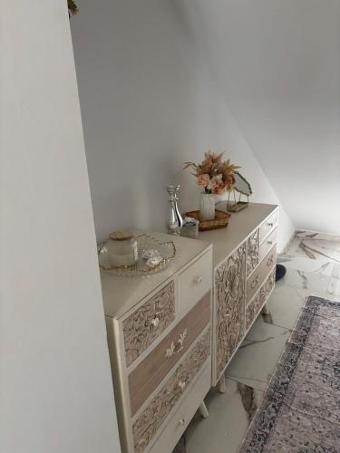 a white dresser with flowers on top of it at La pulga en el océano in Torrelavega