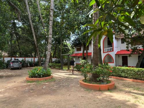 a building with trees and plants in front of it at Vala House in Cherai Beach