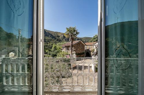 a glass window with a view of a balcony at Refúgio entre o Pomar e o Rio Douro in Raiva