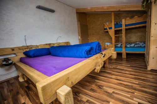 a bedroom with a wooden bed and bunk beds at Steigmatt Bauernhof- Erlebnis in Montlingen