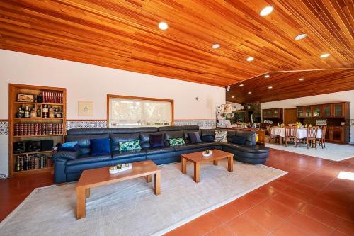 a large living room with a blue couch and tables at Refúgio entre o Pomar e o Rio Douro in Raiva