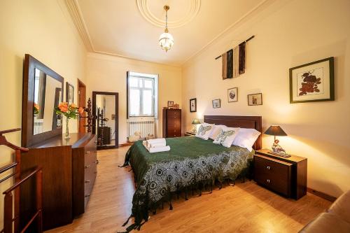 a bedroom with a bed and a dresser at Refúgio entre o Pomar e o Rio Douro in Raiva