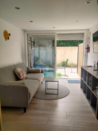 a living room with a couch and a table at Mayka in LʼIsle-sur-la-Sorgue