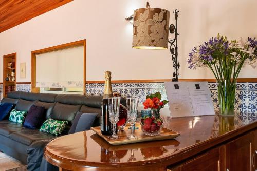 a living room with a table with a bottle of champagne at Refúgio entre o Pomar e o Rio Douro in Raiva