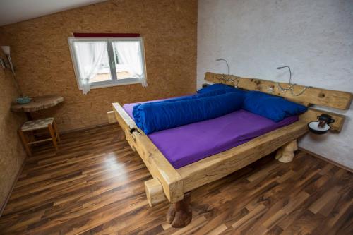 a bedroom with a wooden bed with purple sheets and a window at Steigmatt Bauernhof- Erlebnis in Montlingen