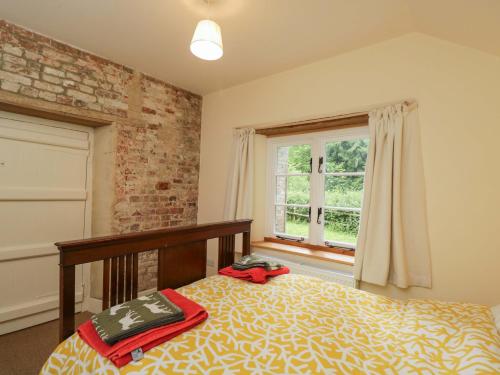 a bedroom with a bed and a window at Keepers Cottage in Devizes