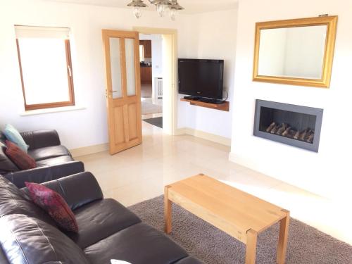 a living room with a couch and a fireplace at Rannagh View in Liscannor